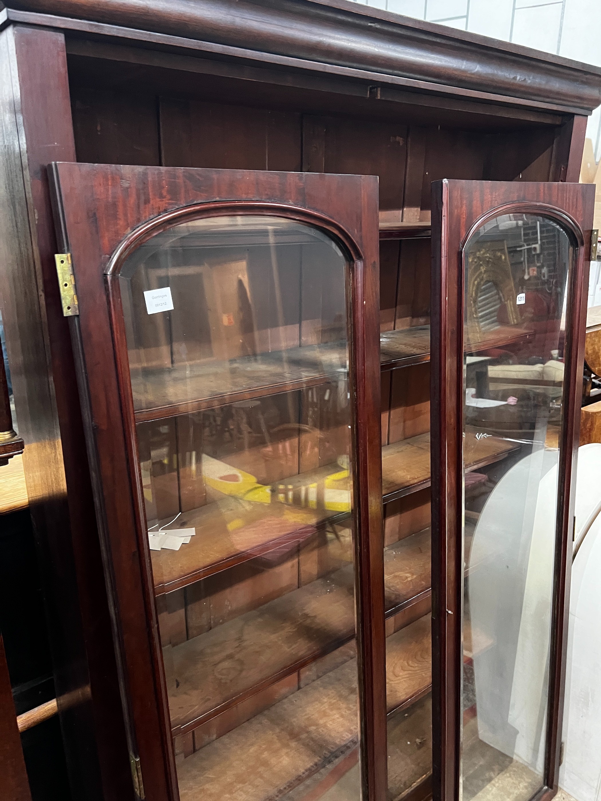 A large mahogany bookcase with two glazed panel doors, width 138cm, depth 31cm, height 209cm